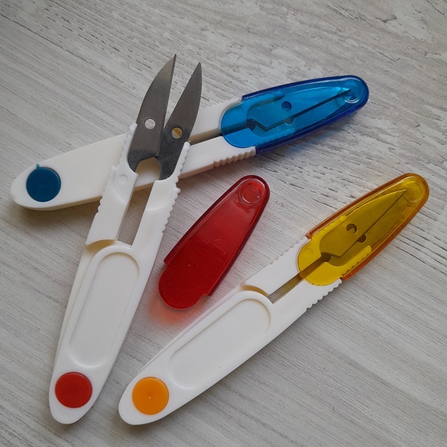 Ножиці для обрізки ниток з кольоровим колпачком.