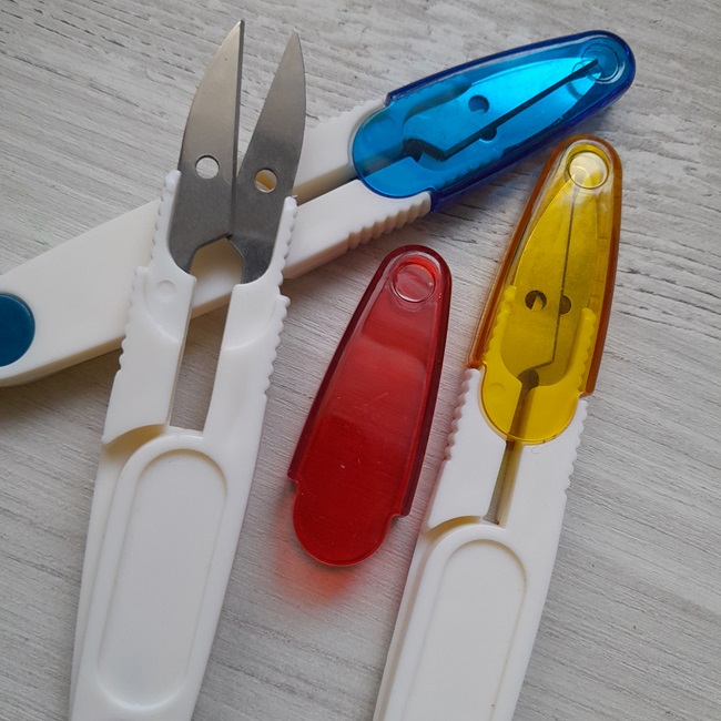 Ножиці для обрізки ниток з кольоровим колпачком.