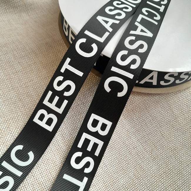Репсова стрічка BEST CLASSIC, 2,5 см, чорна з білими буквами.